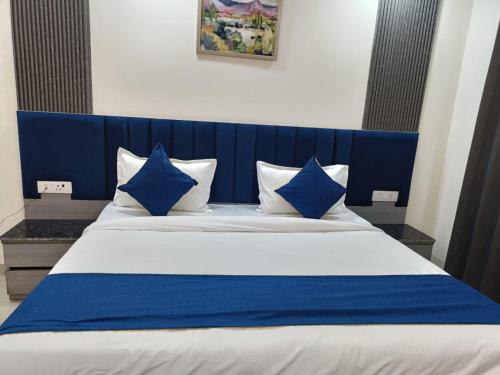a blue and white bed with blue pillows on it at Hotel NYSA Benzo Plaza Near Delhi Airport in New Delhi