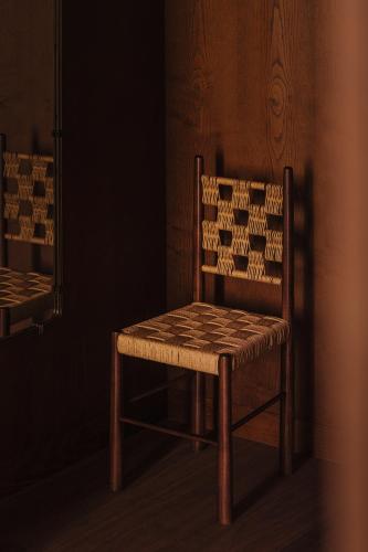 a wooden chair sitting in a corner of a room at Palacio De Godoy Caceres, Curio Collection By Hilton in Cáceres