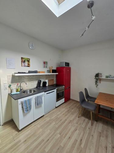a kitchen with a sink and a red refrigerator at ruhiges Apartment mit guter Anbindung in Friedberg
