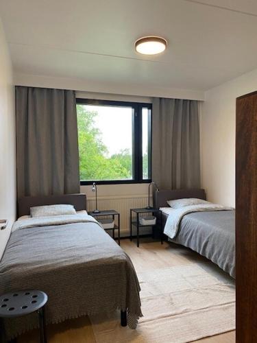 a bedroom with two beds and a large window at Cozy apartment from Raahe! in Raahe