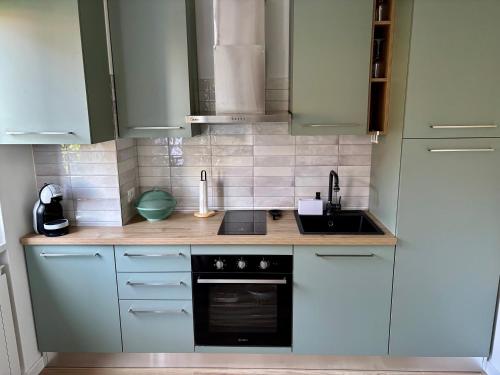 a kitchen with white cabinets and a black oven at Riki House Selvino in Selvino