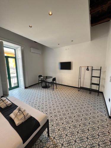 a bedroom with a bed and a table and a tv at Don Raffaé in Nola