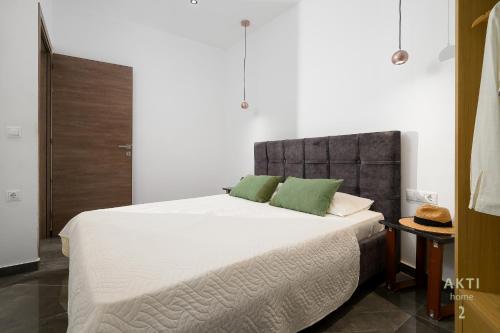 a bedroom with a large white bed with green pillows at AKTI Homes Matala in Matala