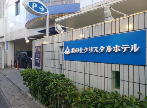 a blue sign on the side of a building at Nami No Ue Crystal Hotel in Naha