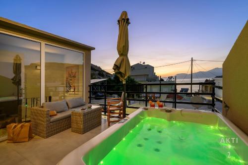 a hot tub on the balcony of a house at AKTI Homes Matala in Matala