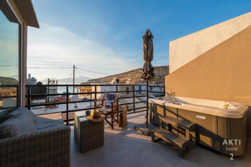 a balcony with a hot tub and a table at AKTI Homes Matala in Matala