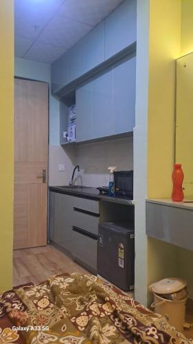a room with a kitchen with a bed and a sink at Kaveri Stay in Greater Noida