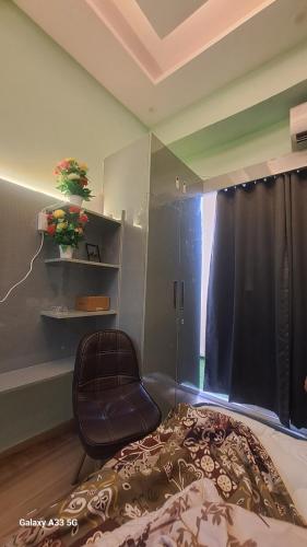 a bedroom with a chair and a bed and a window at Kaveri Stay in Greater Noida