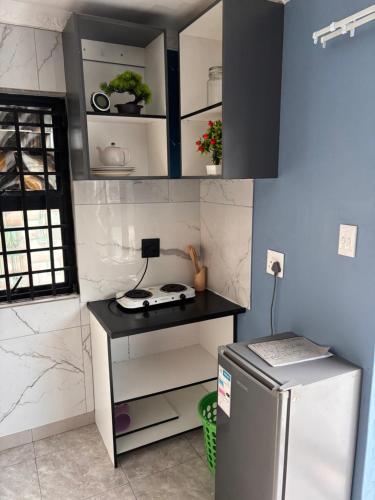 Una pequeña cocina con estufa y refrigerador. en Brown Accomodation, en Cape Town