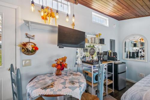 una sala da pranzo con un tavolo e una tv di Cozy Tiny Home Retreat on Shenandoah Valley Farm cabin a Mount Jackson