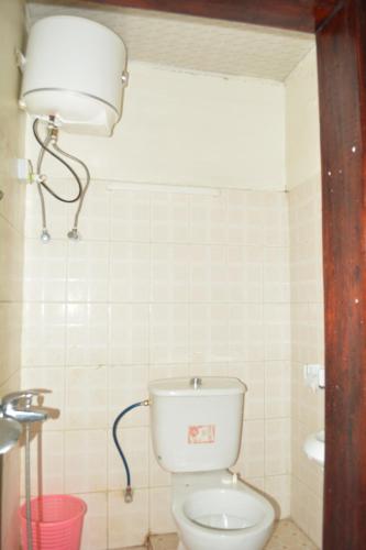 a bathroom with a toilet with a light above it at HOLY LAND RESORT Rw in Ruhengeri