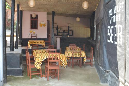 a restaurant with wooden tables and chairs in a room at HOLY LAND RESORT Rw in Ruhengeri