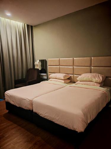 a bedroom with two beds with white sheets and pillows at Comfort Suite in Miri in Miri