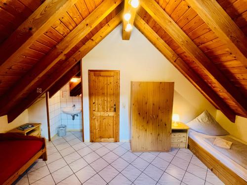 an attic room with wooden ceilings and a bathroom at Ins Scholze große und kleine Ferienwohnungen in Albersbach in Rimbach