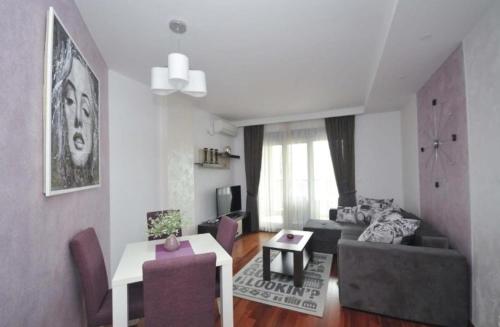 a living room with a couch and a table at Seaside Apartments Petrovac in Petrovac na Moru
