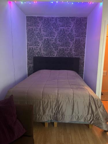 a purple bedroom with a bed with a purple wall at Huoneisto kaupungissa Joensuu in Joensuu