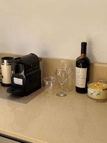a bottle of wine sitting on a counter with glasses at BEACH BAY suit in Shlomi