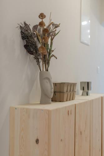 a vase with flowers on top of a wooden shelf at Apartments Sea in Trogir