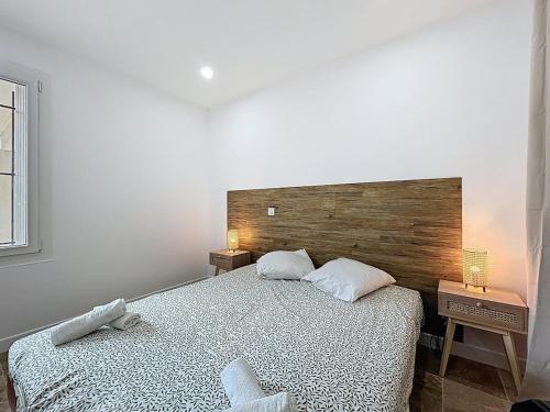 a bedroom with a large bed with a wooden headboard at Lakanaille - Appartement proche du centre - Wifi et Climatisation in Narbonne