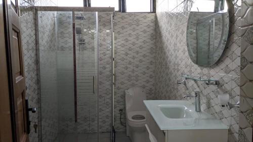 a bathroom with a shower and a toilet and a sink at UMUBANO RESIDENCE KIGALI Kabeza in Kigali