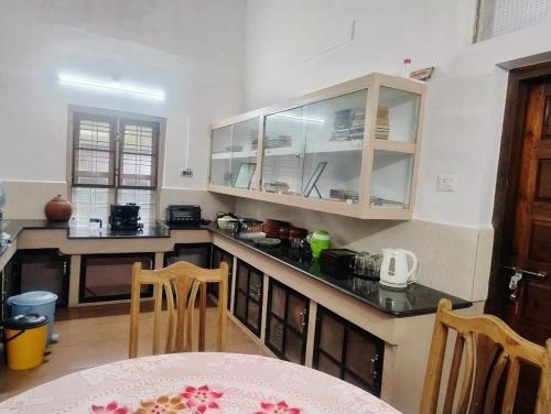 una cocina con una mesa y una encimera en Maanasam Farmstay - Boutique 3BR Countryside Villa, Manikkadavu, en Irrity