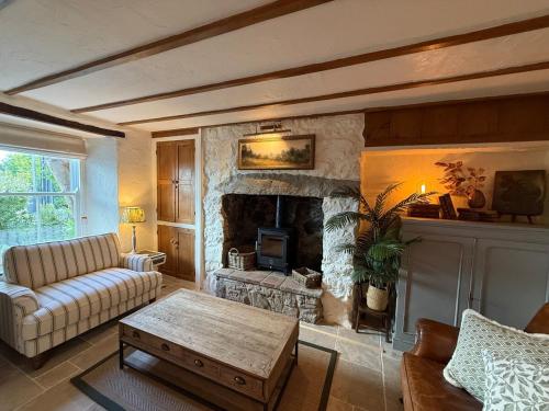 a living room with a couch and a fireplace at Arwel Cottage 3 bedroom in Llanbedrog