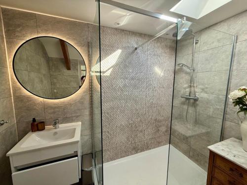 a bathroom with a shower and a sink and a mirror at Arwel Cottage 3 bedroom in Llanbedrog