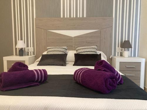 a bedroom with a large bed with purple pillows at Apartamento MAFASCA in Las Playas