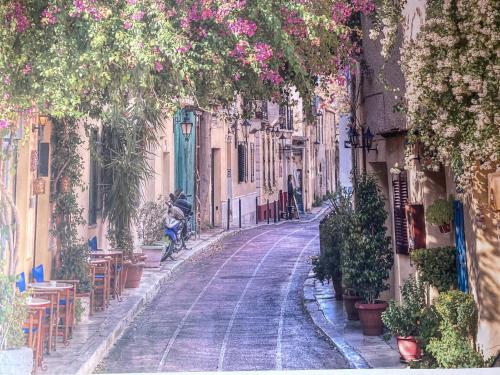 a narrow street with tables and chairs and flowers at Apartamento MAFASCA in Las Playas