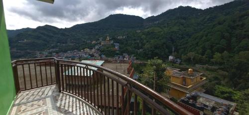 a balcony with a view of a town in the mountains at Nitin Home Stay in Rewalsar