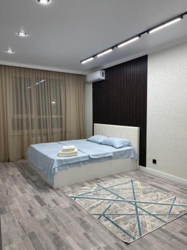 a bedroom with a large bed with blue sheets at Grandpark in Shymkent