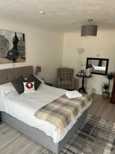 a bedroom with a large bed and a chair at Oliver Twist Country Inn in Wisbech