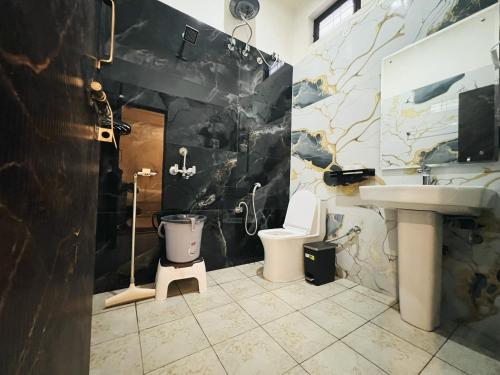 a bathroom with a toilet and a sink at Live Free Hostel Dehradun in Dehradun