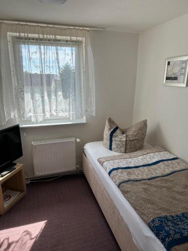 a small bedroom with a bed and a window at Gasthof & Pension Zum Saalestrand in Bad Dürrenberg