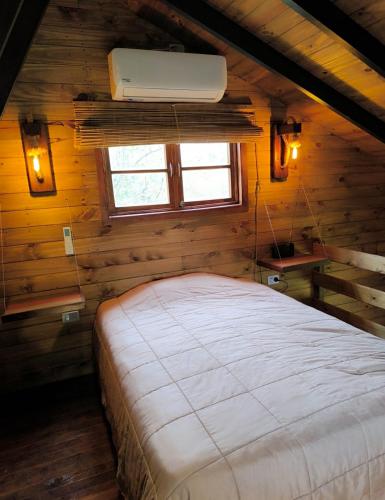 a bedroom with a bed in a wooden cabin at casa alpina Maxi premiun in Tigre