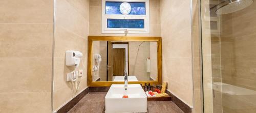 a bathroom with a sink and a mirror at Royal Mandarin Hotel & Resort in Pwani Mchangani