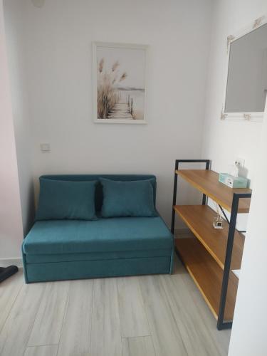 a blue couch in a room with a table at Studio Vata in Vaţa de Jos