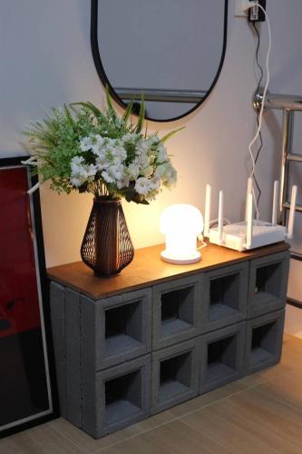 a table with a vase of flowers and candles on it at Ananta House in Bang Su