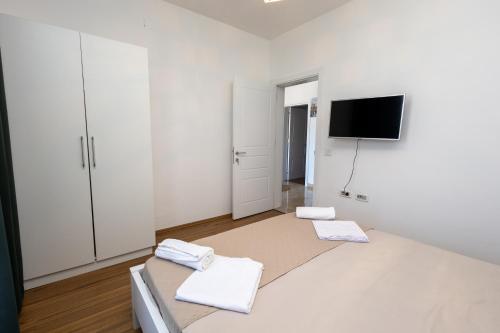 Una habitación blanca con una cama con toallas. en LuxuryHomeUlcinj, en Ulcinj
