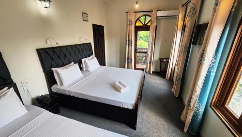 a bedroom with a bed with a headboard and a window at Rumaisa Hotel in Zanzibar City