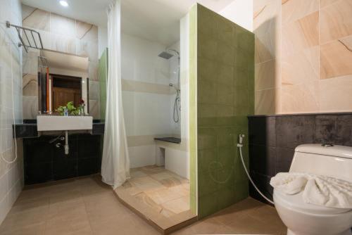a bathroom with a shower and a toilet and a sink at Baan Vanida Garden Resort in Karon Beach