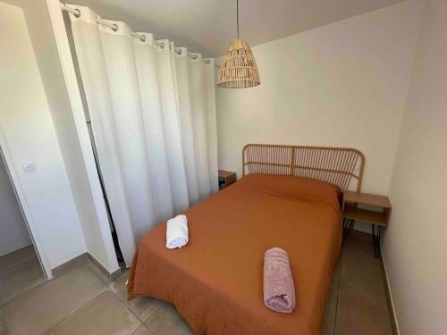 une chambre avec un lit avec deux serviettes dessus dans l'établissement La Cime Appart Neuf au Port, Clim, Wifi, Parking, Plage, à Valras-Plage