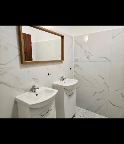 a white bathroom with a sink and a mirror at Lipowa Guest House in Bielawa