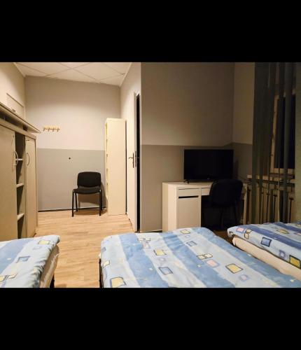 a small room with two beds and a television at Lipowa Guest House in Bielawa