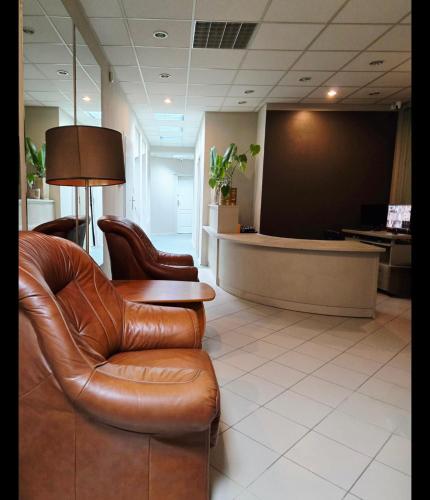 a waiting room with leather chairs and a waiting desk at Lipowa Guest House in Bielawa