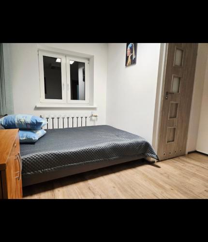 a bed in a room with a window and a door at Lipowa Guest House in Bielawa