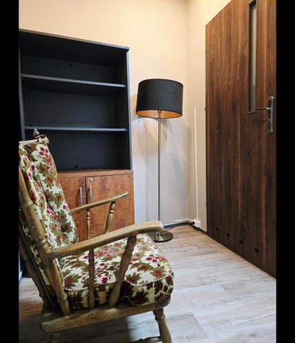 a living room with a chair and a lamp at Lipowa Guest House in Bielawa