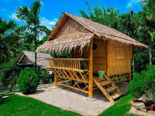 a small hut with a thatched roof and a staircase at คุ้มกะลาหัวฟาร์มสเตย์ (Khumkalahua Farmstay) in Ban Pha Saeng Lang