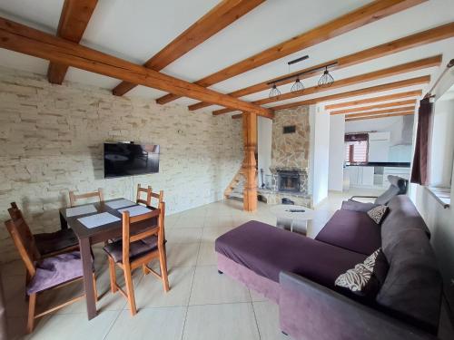 Una sala de estar con un sofá morado y una mesa. en Dom u Julii Bieszczady, en Ustrzyki Dolne