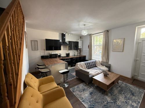 a living room with a couch and a kitchen at Bradford Serviced Accommodation - Apartments - 2 Bed House-Close To Centre - Hospital - Contractors - Business Travellers - Families in Bradford